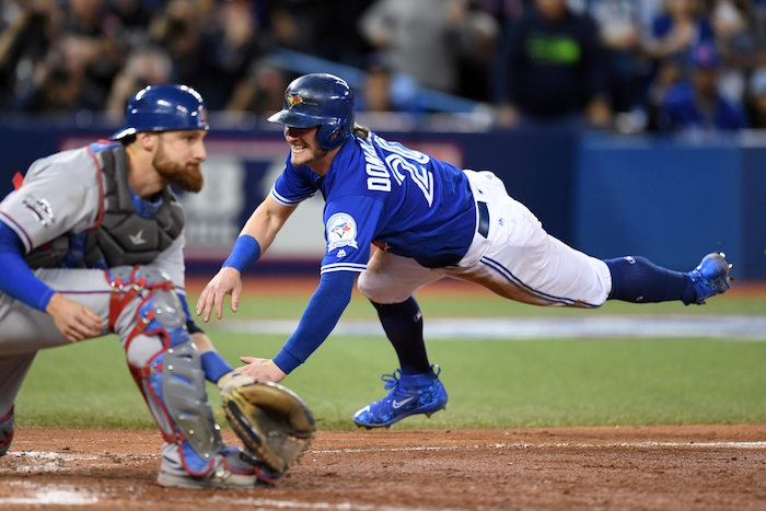 Toronto Blue Jays' Josh Donaldson slides in to score the winning run past Texas Rangers' catcher Jonathan Lucroy during tenth inning game three American League Division Series action, in Toronto on Sunday, October 9, 2016. THE CANADIAN PRESS/Frank Gunn