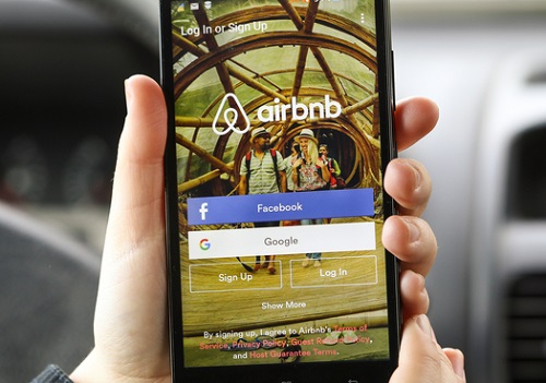 Novi Sad, Serbia - March 24, 2016: Close-up of an unrecognizable woman using the Airbnb App on her Lenovo A916 Android smartphone in a car. Login screen with Facebook and Google sign up options. Airbnb is a service for people to list, find, and rent lodging. It currently has over 1,500,000 listings in 34,000 cities and 190 countries.