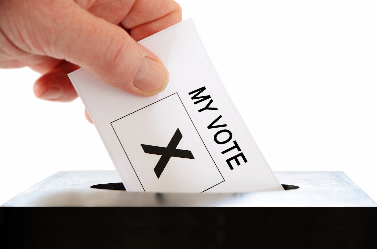 A hand placing a voting slip into a ballot box over a white background